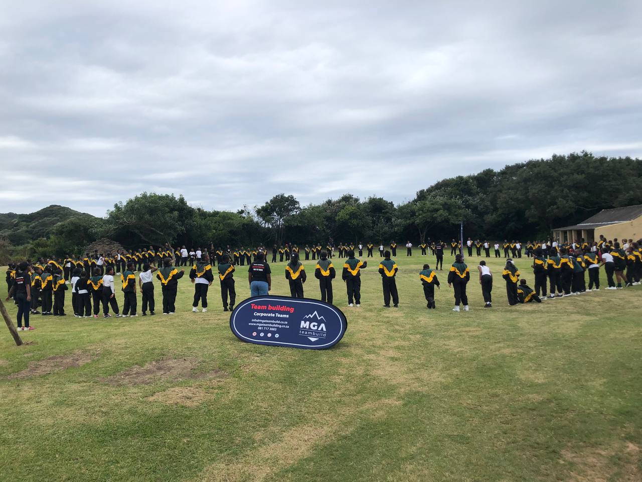 A large MGA group gathered in a circle on an outdoor field