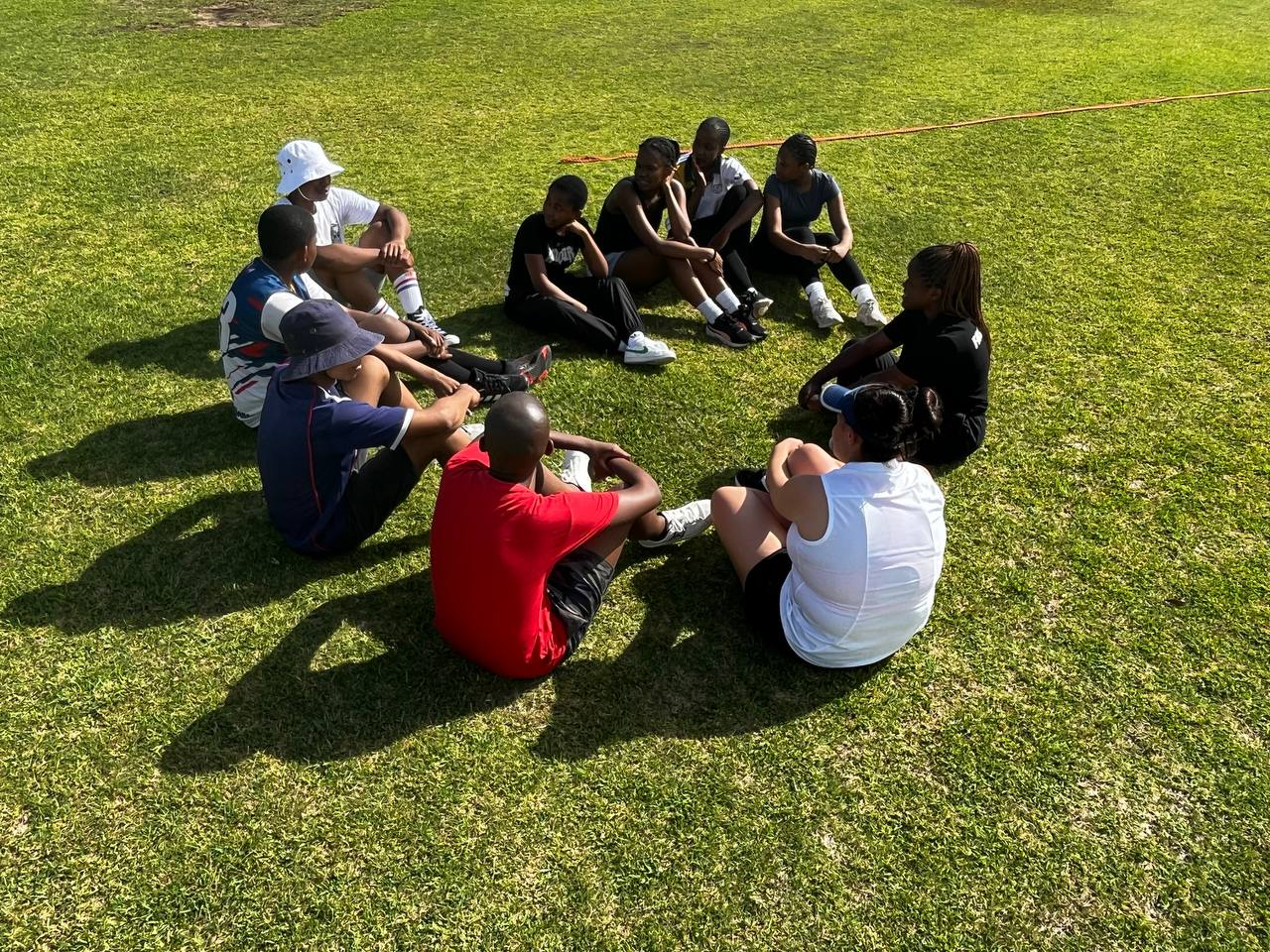 Participants seated in a circle for team reflection after activities