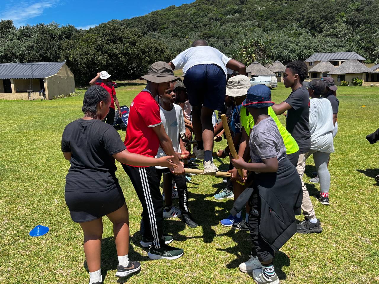 A team working together to support a participant on a platform challenge
