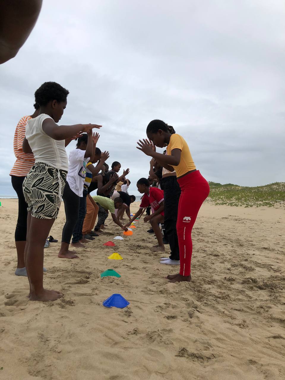 A group completing an MGA team challenge on an Eastern Cape beach